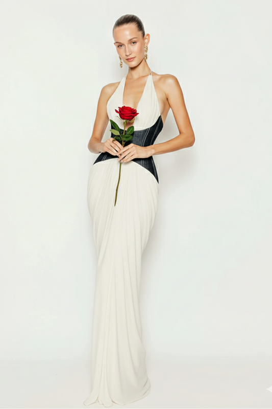 Woman in a white and black dress holding a red rose against a white background