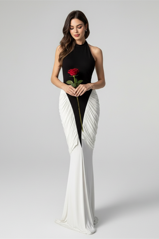 Woman in a black and white dress holding a red rose on a gray background