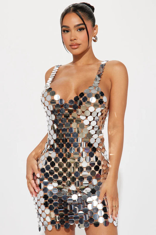 Woman wearing a metallic sequin dress on a white background