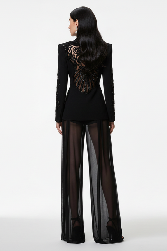 Person wearing a black outfit with sheer pants on a white background