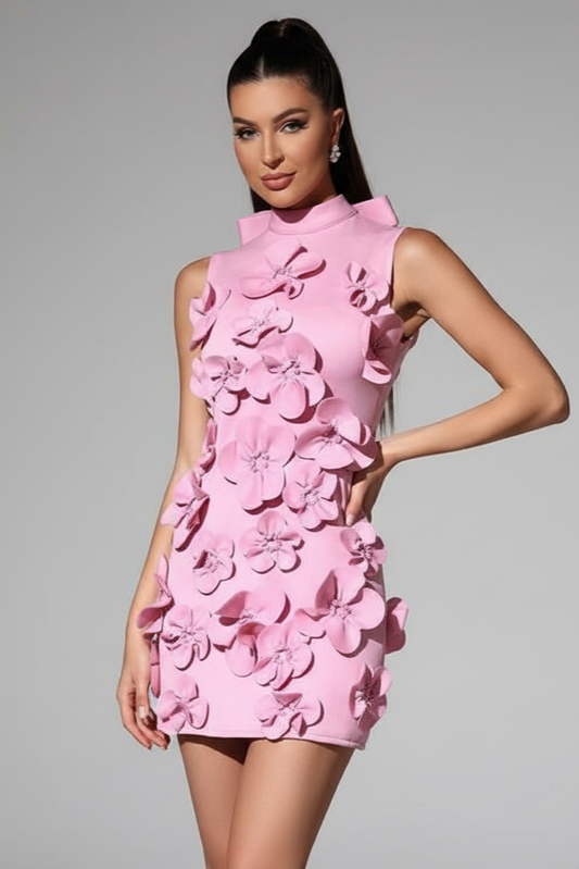 Pink dress with floral patterns worn by a model on a gray background