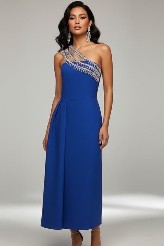 Woman wearing a blue one-shoulder dress with silver embellishments on a gray background