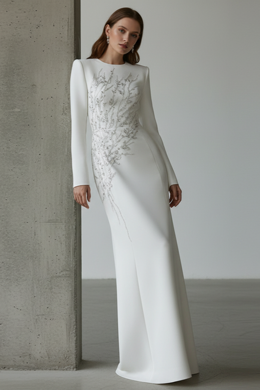 Woman wearing a white wedding dress with intricate detailing against a neutral background