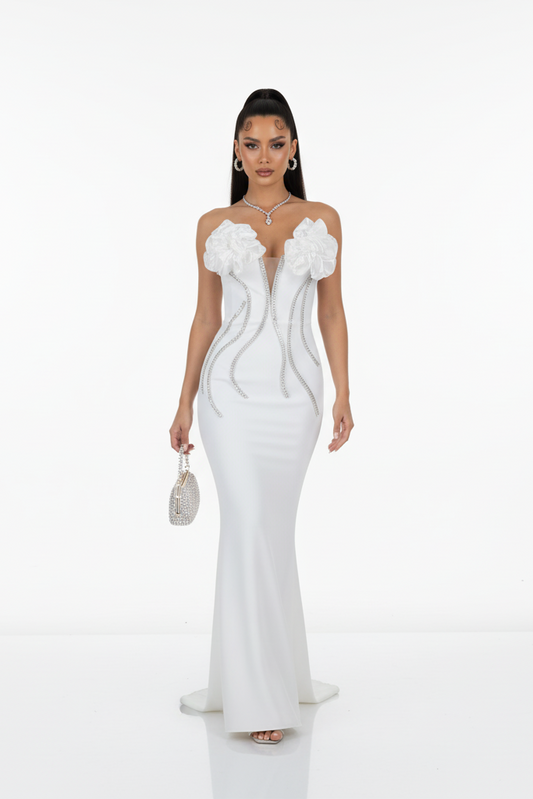 Woman wearing a white evening gown with floral details on a white background