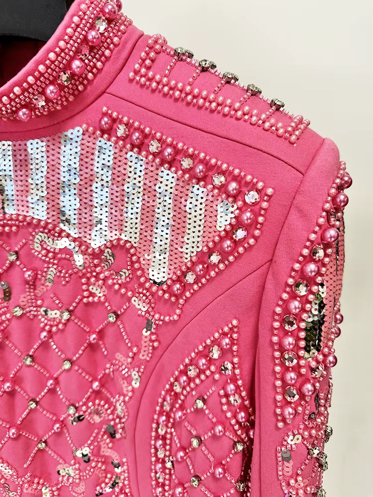 Close-up of a pink garment with intricate bead and sequin detailing.