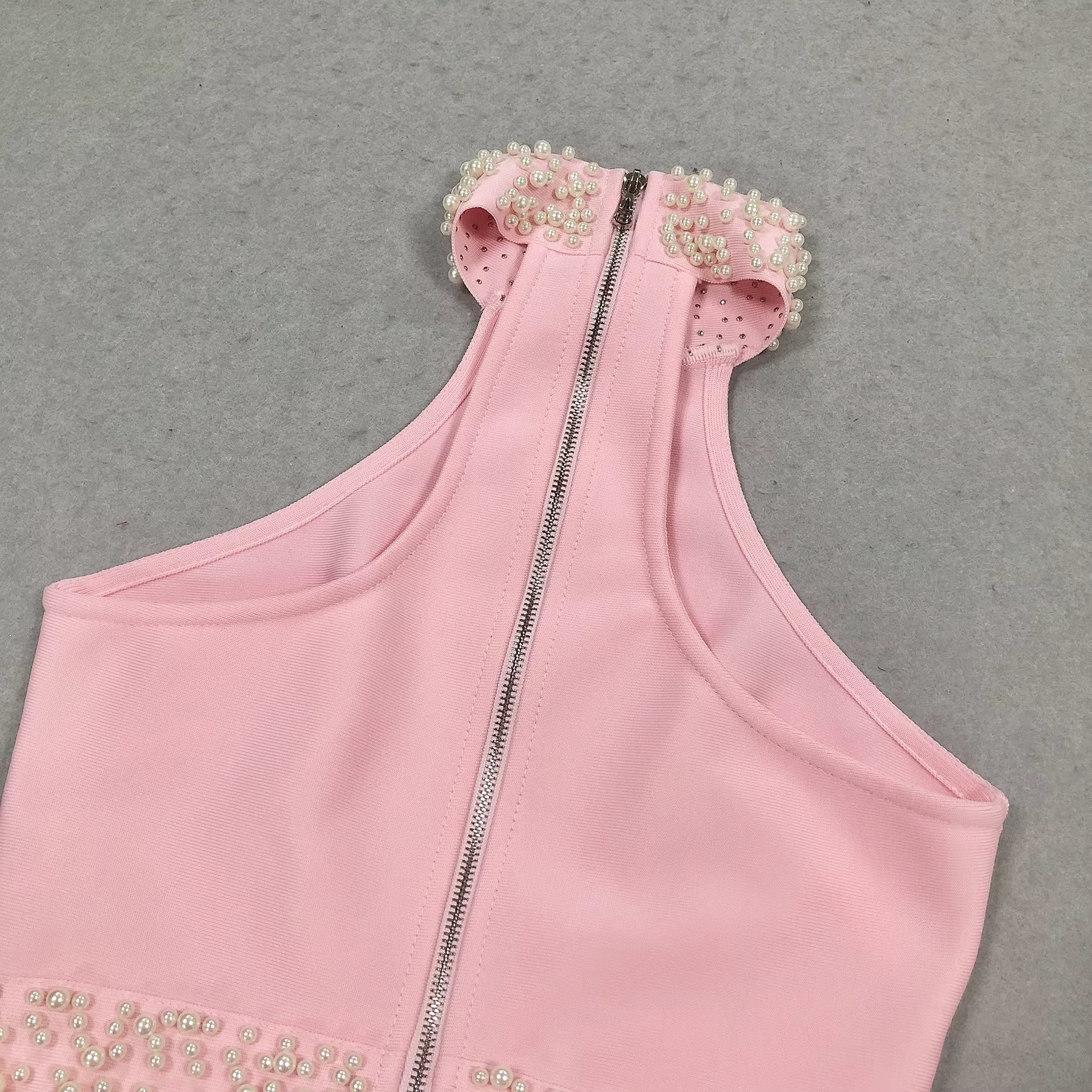 close-up of Luxe Lane pink bandage fabric with pearl waist embellishment and smooth stitching
