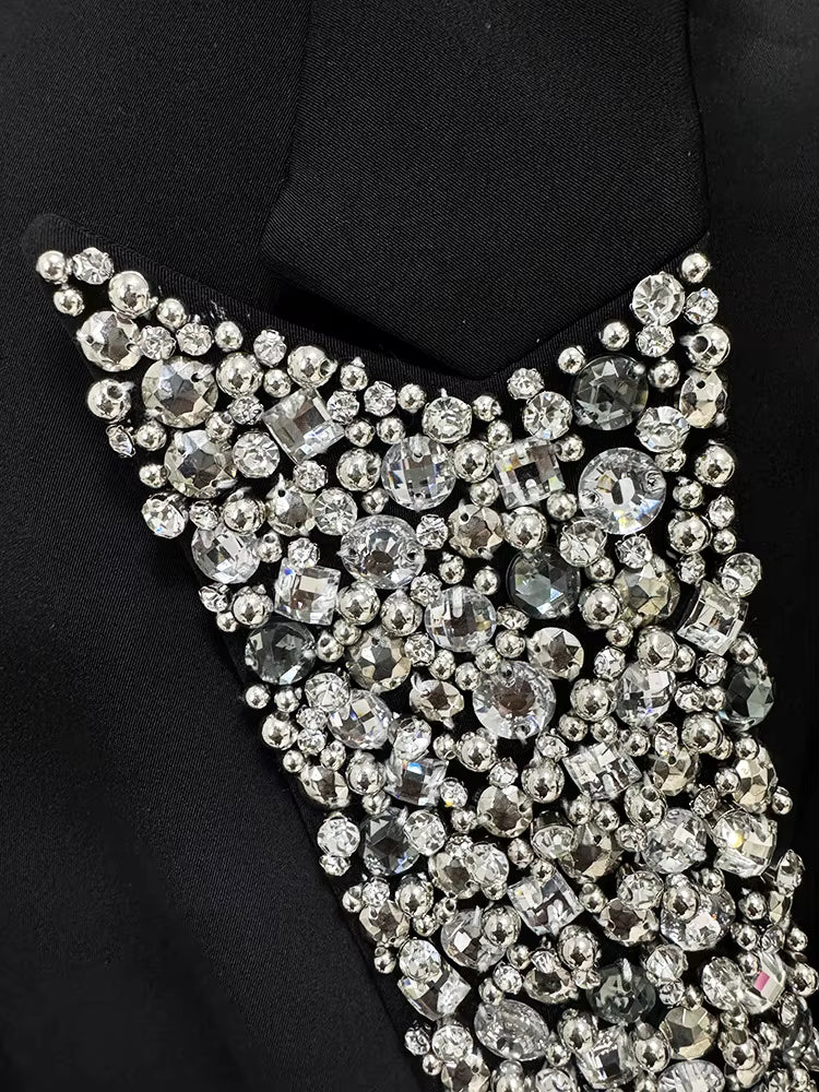 Close-up of a black garment with a decorative silver and crystal embellishment.