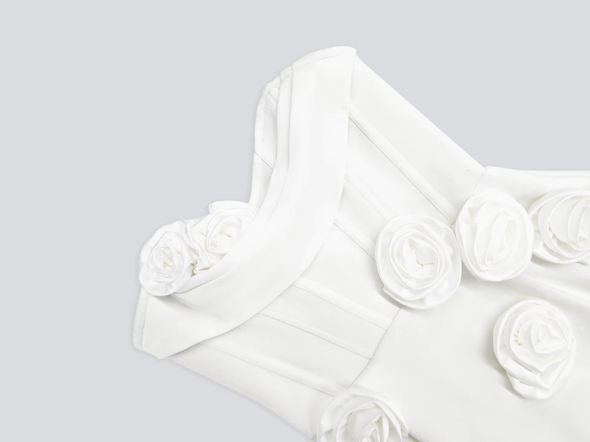 White fabric with floral embellishments on a light gray background