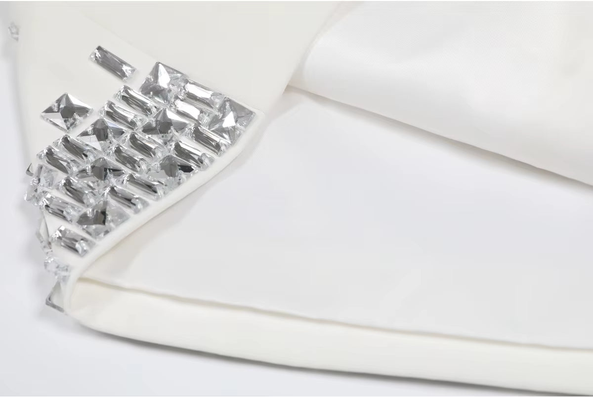 Close-up of a white shoe with crystal embellishments on a light background