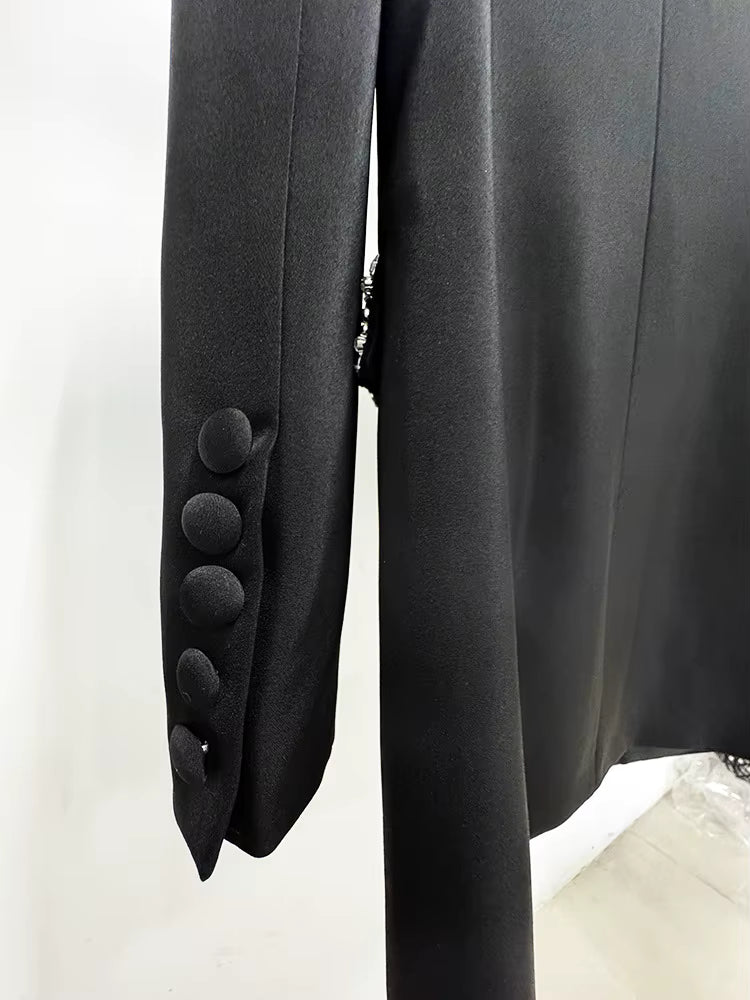 Close-up of a black blazer with buttons on a white background