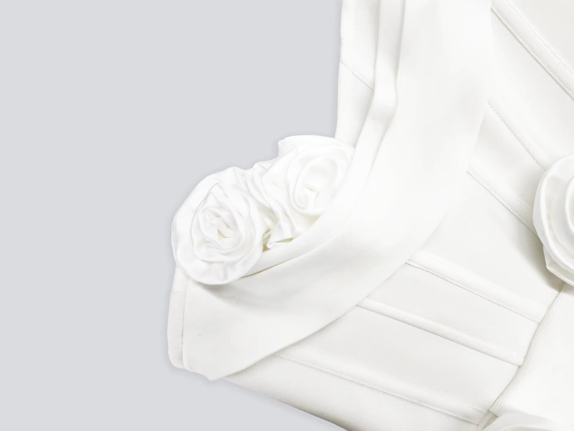 White fabric with floral embellishments on a light gray background