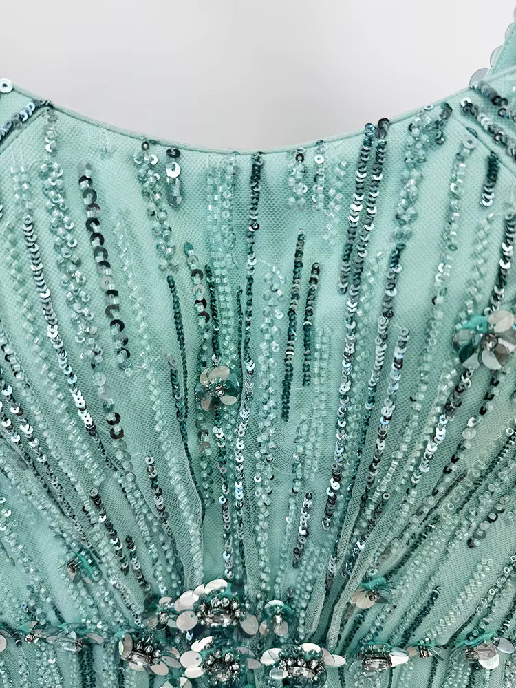 close-up of Luxe Lane aqua sequin mesh fabric with silver bead embellishments and fine texture
