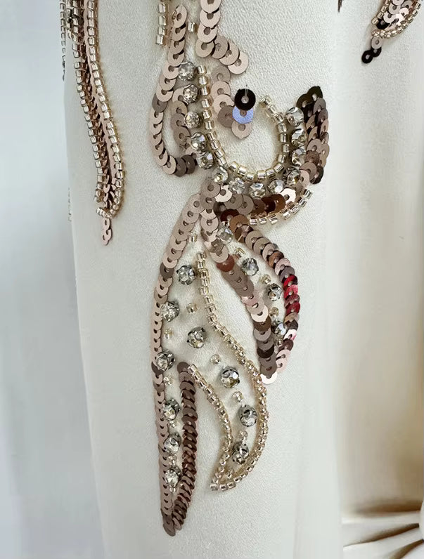 Decorative necklace with sequins and beads on a white stand