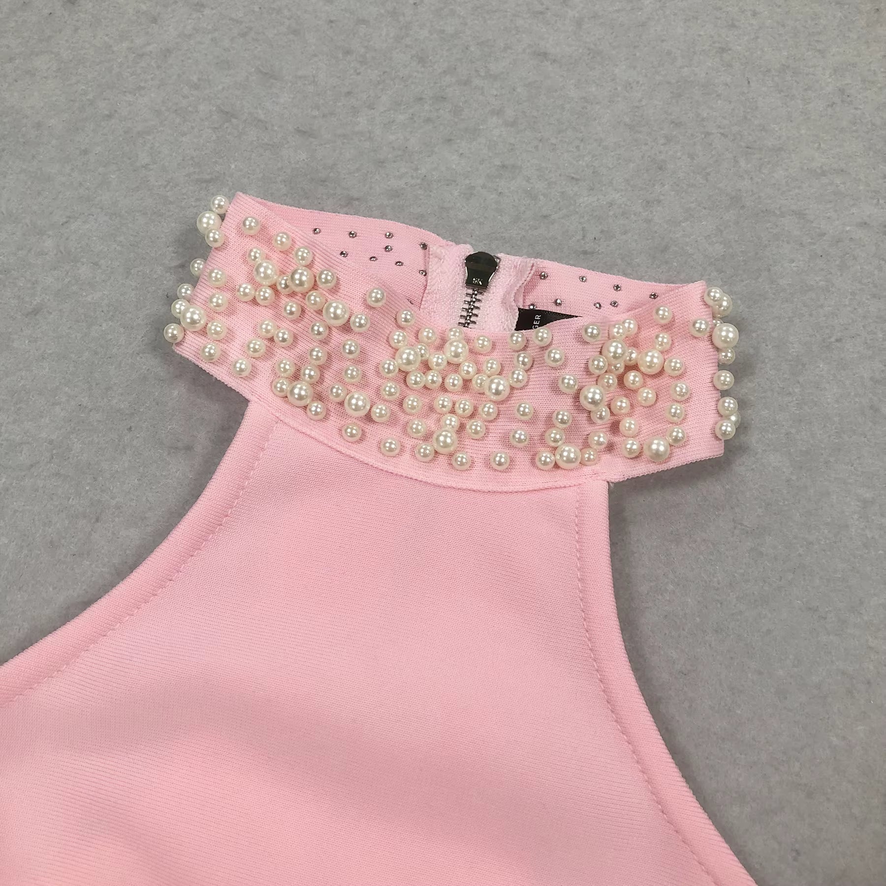 close-up of Luxe Lane pink crop top neckline with pearl beaded trim and fine stitching
