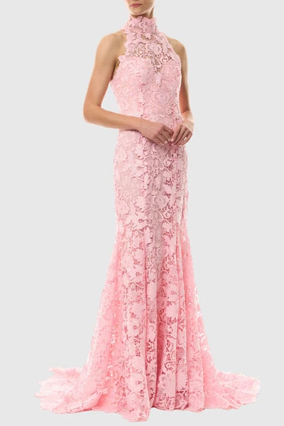 A pink lace halter-neck evening gown with a high neck, fitted silhouette, and flared mermaid-style hem with a slight train, shown on a model against a light gray background.