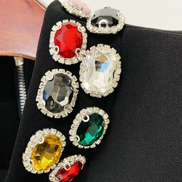 Aurora Gemstone Mini Gown by Luxe Lane | from Luxe Lane | SKU:  | Barcode:  | Options: Black S | close - up of Luxe Lane black gemstone detailing showing vibrant red, green, and gold jewels on fabric