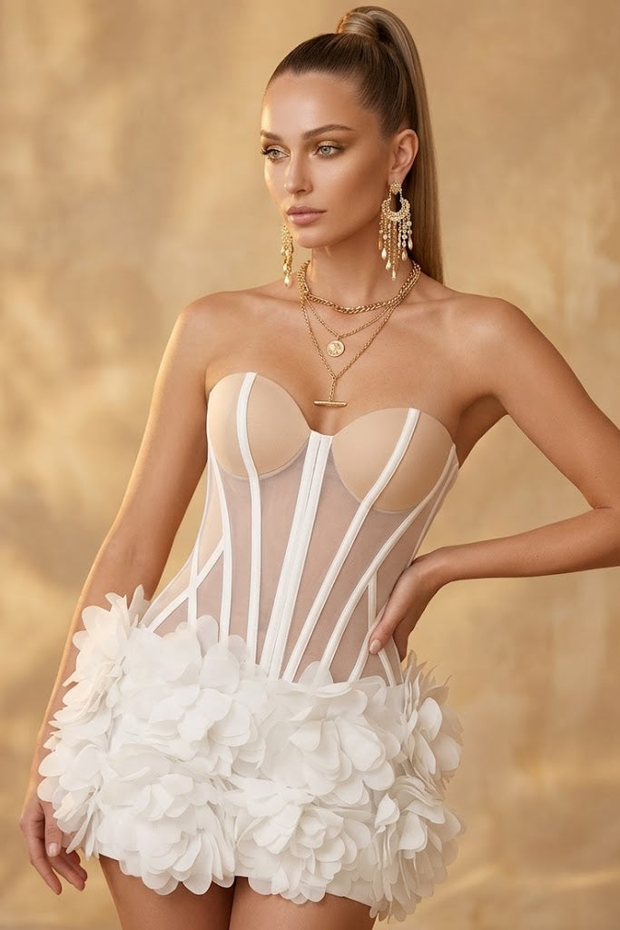 Woman wearing a sheer white corset with floral details against a beige background