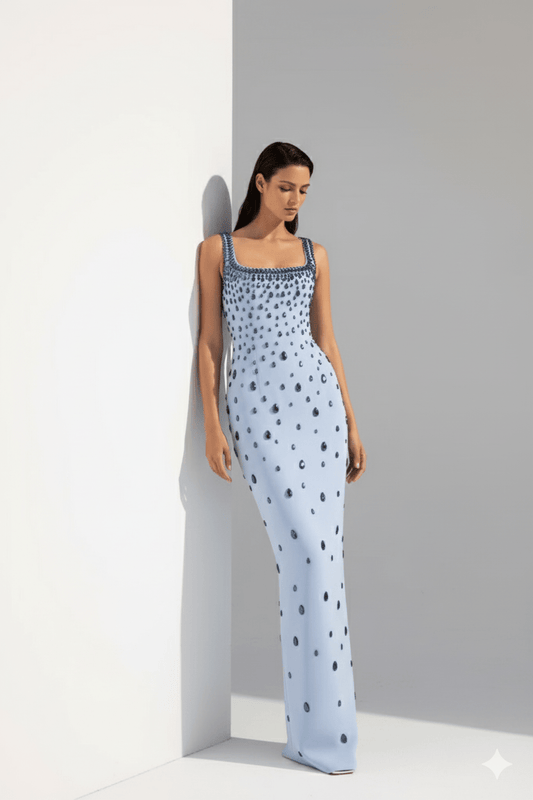 Celeste Grace Gown by Luxe Lane | heath gown from Luxe Lane | SKU:  | Barcode:  | Options: Light Blue S | Woman wearing a light blue jumpsuit with a subtle pattern against a gray background