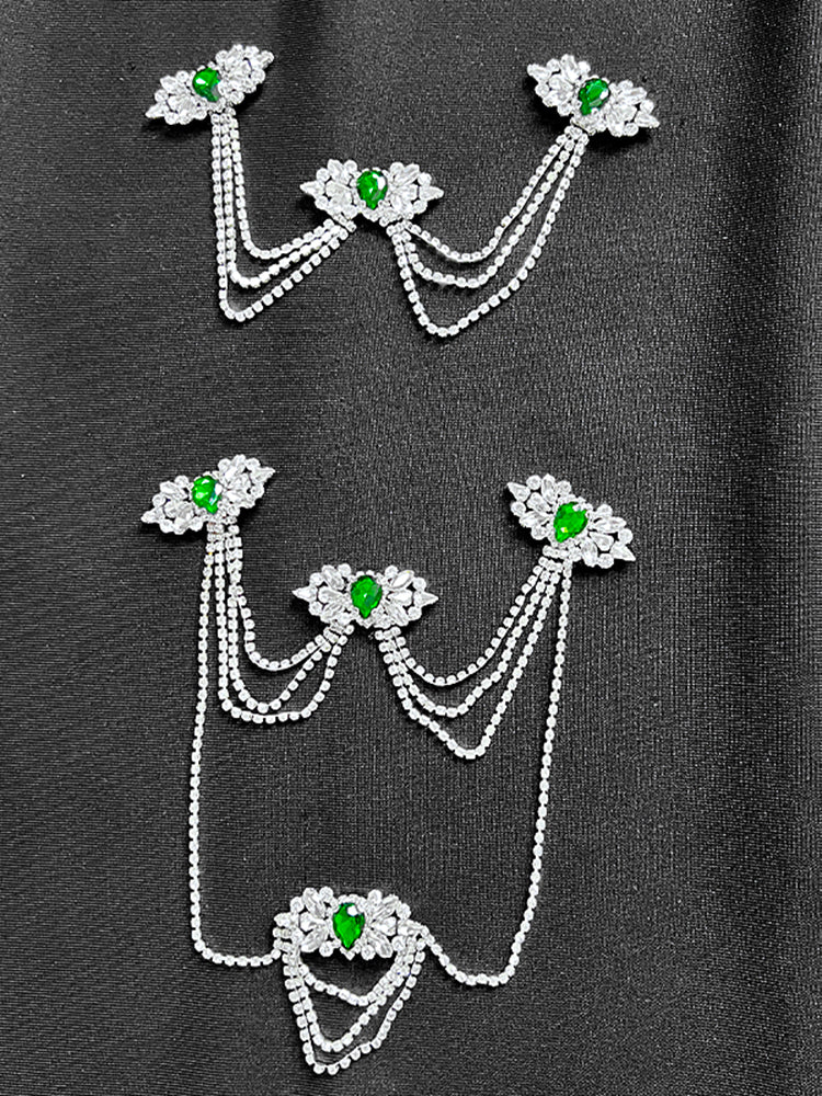 Celestia Noir Gown – Black Strapless by Luxe Lane | mermaid gown from Luxe Lane | SKU:  | Barcode:  | Options: Black S | Decorative brooches with green gemstones and pearl - like chains on a dark background