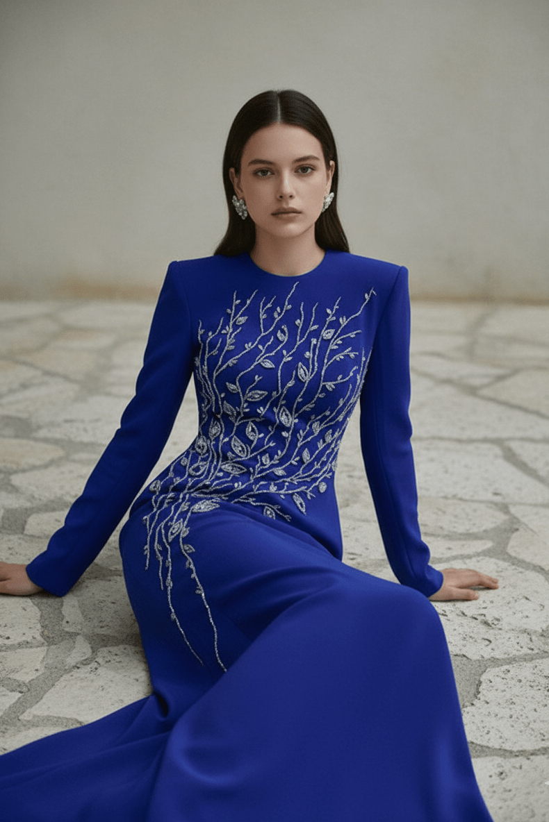 Elaria Beaded Rhinestone Floral Gown by Shine | from Luxe Lane | SKU: W11288-13 | Barcode:  | Options: Blue S | Woman wearing a blue evening gown with intricate white detailing on a stone floor.