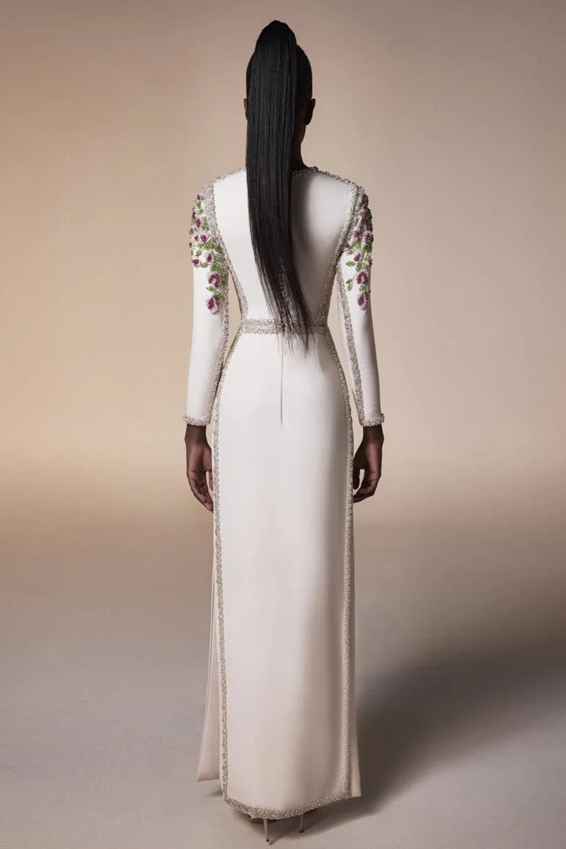 Floral Embroidered Long Sleeve Bodycon Maxi Evening Dress by Luxe Lane | Party dresses from Luxe Lane | SKU: W11638-1 | Barcode:  | Options: White S(2) | Woman wearing a long, elegant dress with floral embroidery on a beige background