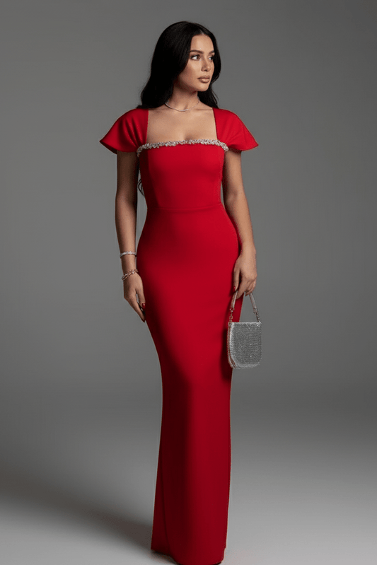 Maxi GownEvening Gown by Luxe Lane | from Luxe Lane | SKU:  | Barcode:  | Options: Red XS | Woman in a red evening gown holding a silver handbag against a gray background