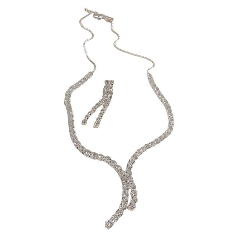 Fringe Rhinestone Necklace & Earrings Set by CJ | 0 from Luxe Lane | SKU: CJLX246751507GT | Barcode:  | Options: Silver Set F | Silver necklace with a bow - shaped pendant on a white background