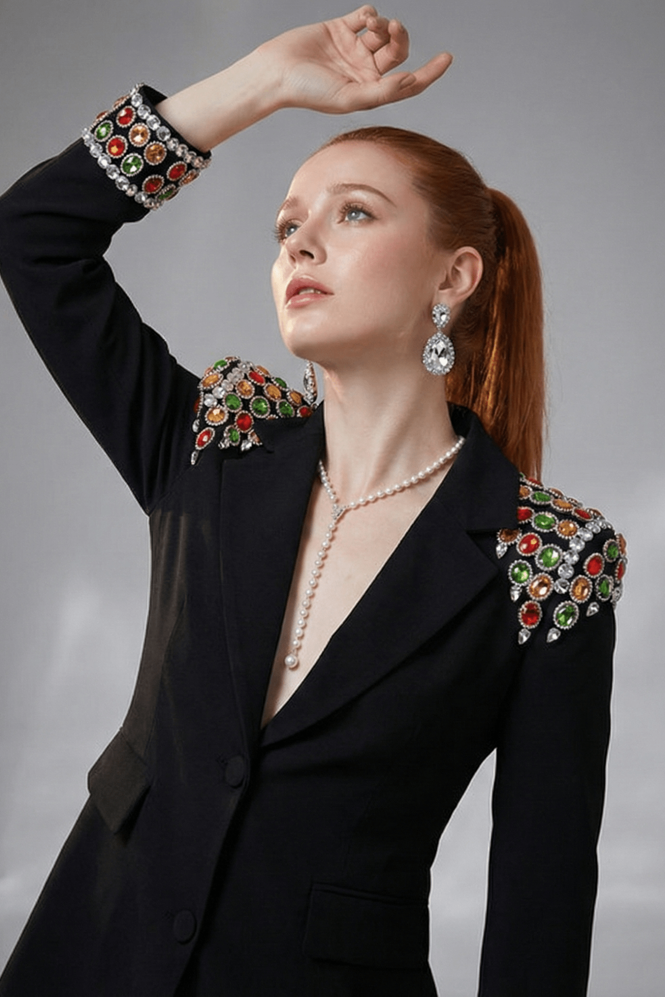 Gemstone Shoulder Tailored Long Blazer Jacket by Luxe Lane | Outerwear from Luxe Lane | SKU: -1 | Barcode:  | Options: Black S(2) | Woman wearing a black blazer with colorful embellishments on a gray background