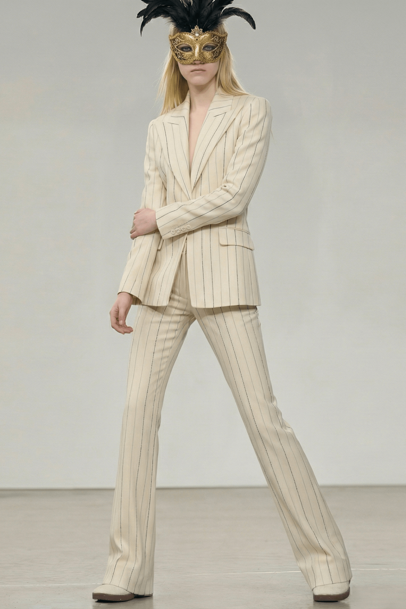 Ivory Pinstripe Tailored Blazer & Flared Pants Suit by Shine | Blazer from Luxe Lane | SKU:  | Barcode:  | Options: S(2) | Person wearing a cream pinstripe suit with a gold mask on a plain background