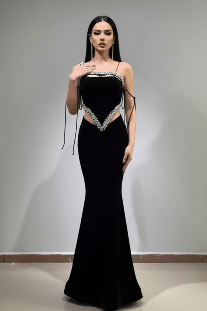 Novara Crystal Velvet Mermaid Gown by Luxe Lane | Party dresses from Luxe Lane | SKU:  | Barcode:  | Options: Black S | Woman wearing a black evening gown with cut - out design against a plain background