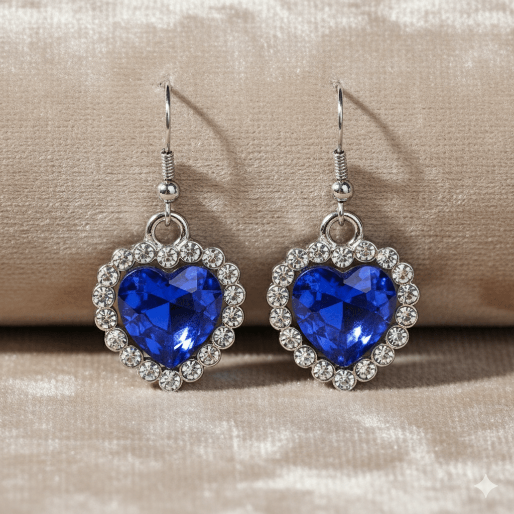 Ocean Heart Necklace & Earring Set by CJ | 0 from Luxe Lane | SKU: CJLX143524601AZ | Barcode:  | Options: Bracelet & Earrings Set | Heart - shaped blue gemstone earrings with silver accents on a beige background