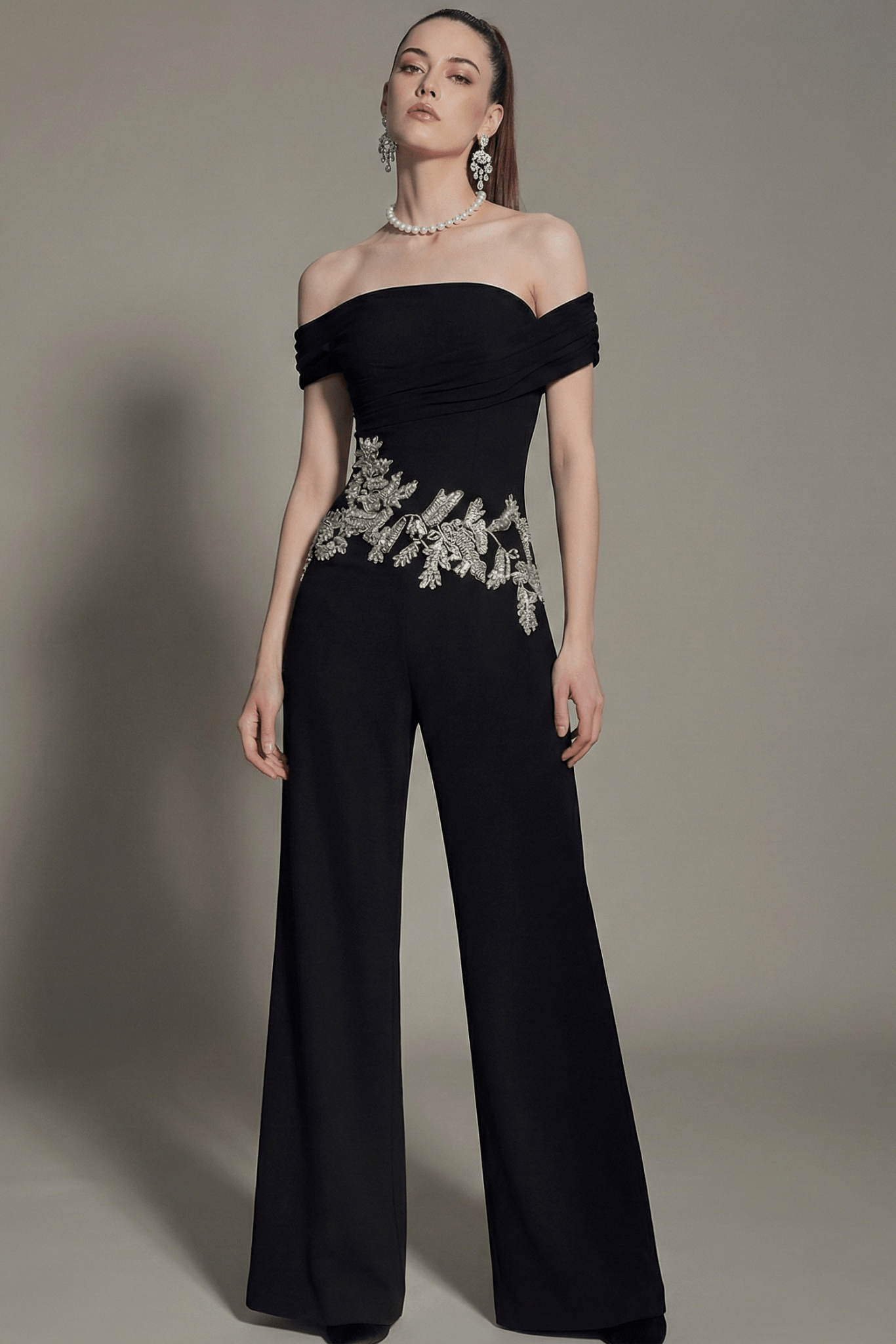 Off - Shoulder Rhinestone Wide - Leg Party Jumpsuit by Shine | Jumpsuit from Luxe Lane | SKU: -1 | Barcode:  | Options: Black S(2) | Woman wearing a black off - shoulder jumpsuit with silver embellishments on a gray background