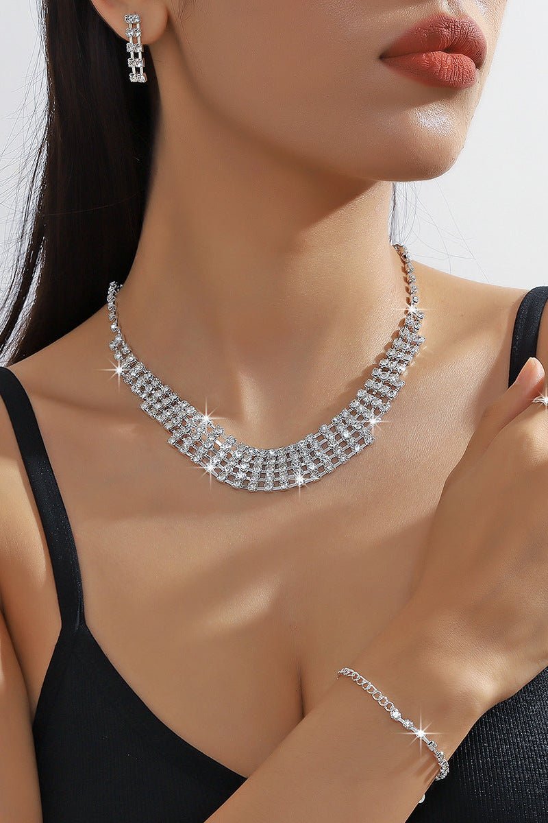 Rhinestone Chain Jewelry Set – Necklace, Bracelet & Earrings by CJ | 0 from Luxe Lane | SKU: CJLX232427001AZ | Barcode:  | Options: | Woman wearing a diamond necklace, earrings, and ring with a blurred background