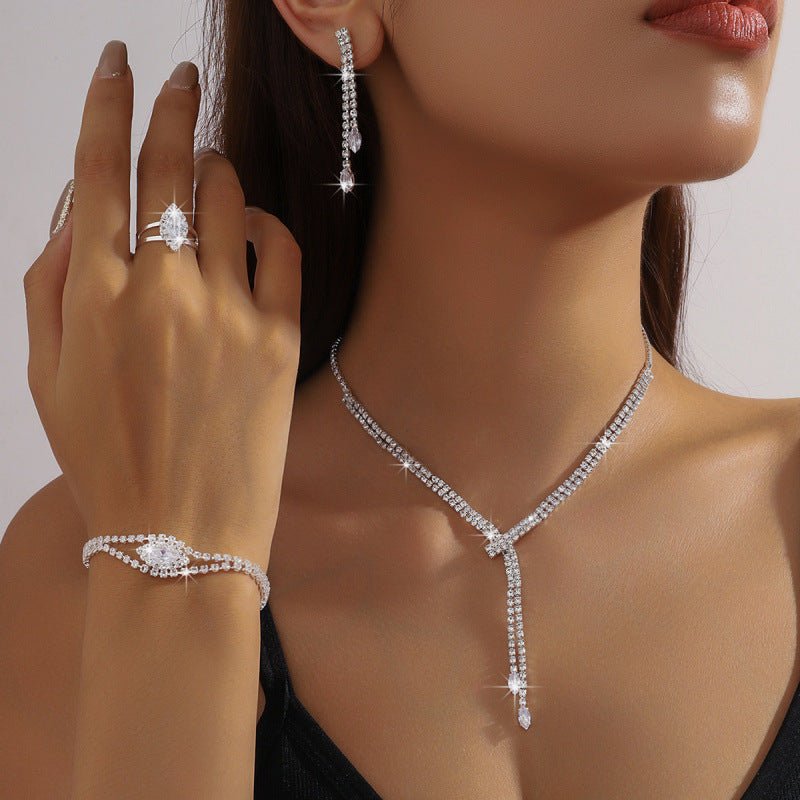 Rhinestone Necklace, Earrings, Bracelet & Ring Set by CJ | jewelry from Luxe Lane | SKU: CJLX224429501AZ | Barcode:  | Options: | Close - up of a woman wearing diamond jewelry including earrings, ring, and bracelet on a neutral background.