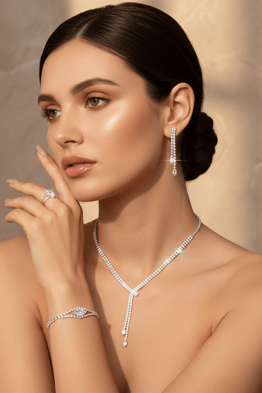 Rhinestone Necklace, Earrings, Bracelet & Ring Set by CJ | jewelry from Luxe Lane | SKU: CJLX224429501AZ | Barcode:  | Options: | Woman wearing a diamond necklace, earrings, and ring against a beige background
