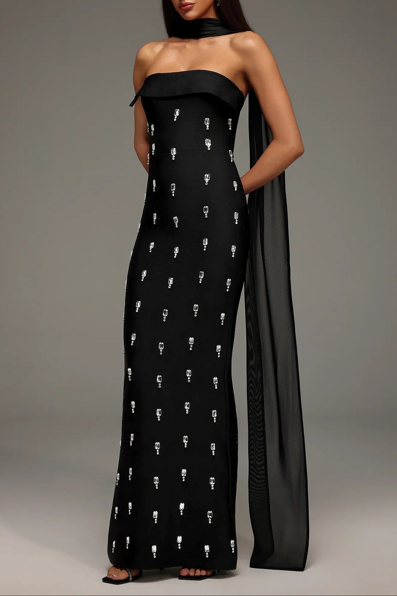 Rhinestone Scarf - Neck Off - Shoulder Bodycon Maxi Evening Dress by Shine | heath gown from Luxe Lane | SKU: -1 | Barcode:  | Options: Black S(6) | Woman wearing a black strapless gown with white patterns on a gray background