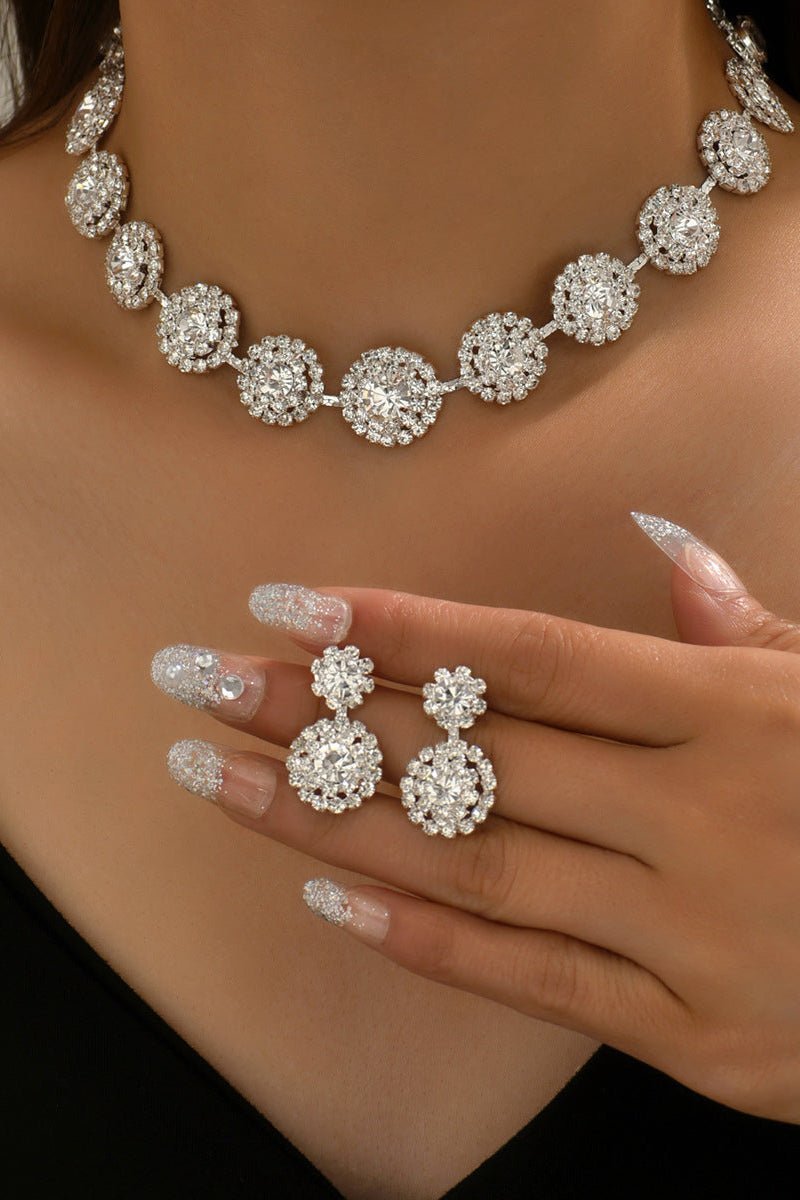 Round Rhinestone Quartz Necklace & Earrings Set by CJ | 0 from Luxe Lane | SKU: CJLX246901901AZ | Barcode:  | Options: White | Silver necklace and earrings on a person with a neutral background