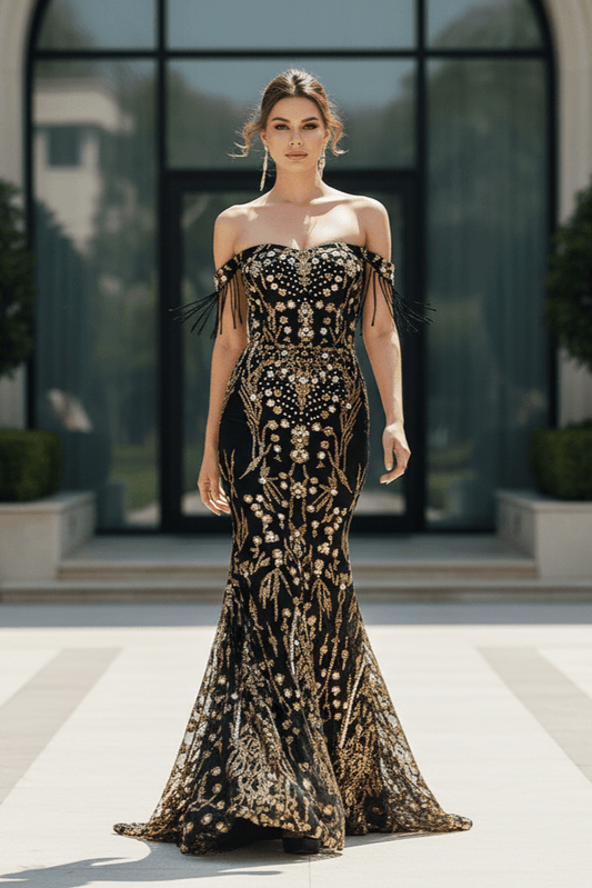 Seraphine Black & Gold Mermaid Gown by Luxe Lane | mermaid gown from Luxe Lane | SKU: -1 | Barcode:  | Options: Black S | Woman in an elegant black and gold dress standing on a pathway with greenery and a building in the background.