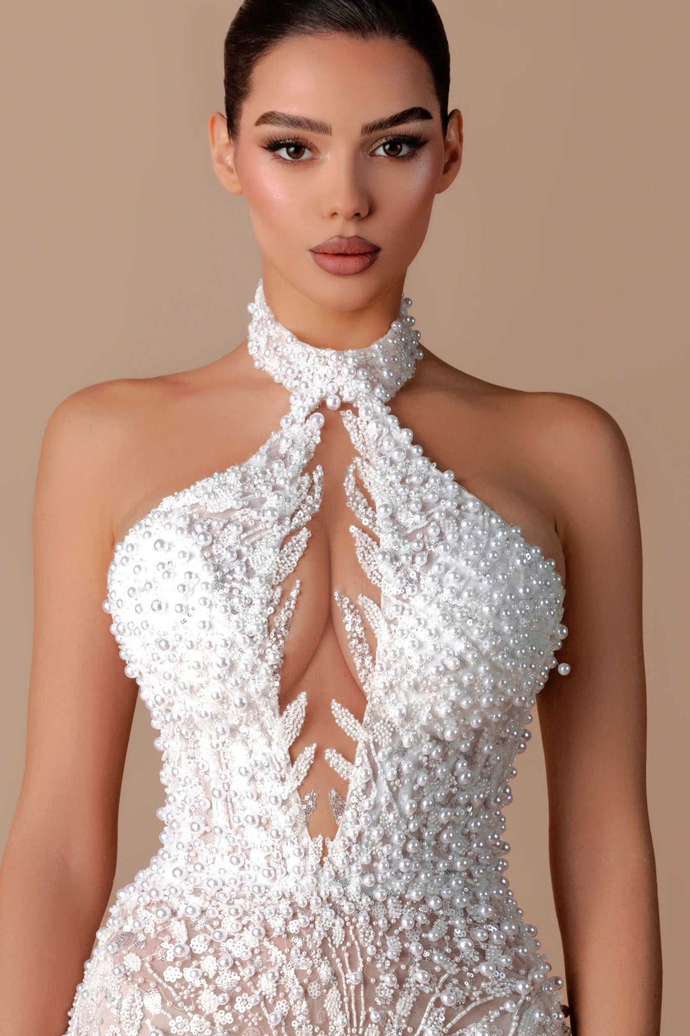 White Sequin Halter Backless Mermaid Evening Gown by Luxe Lane | mermaid gown from Luxe Lane | SKU: W11508-1 | Barcode:  | Options: White XS(0) | Woman wearing a white beaded halter neck dress against a beige background