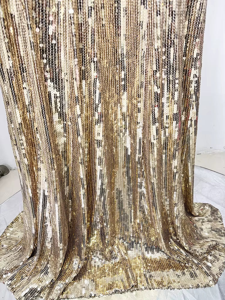 Close-up of a gold and silver sequin fabric draped over a surface.